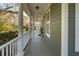 Charming front porch with white columns, outdoor lighting, and views of the surrounding landscape at 1504 Galloway Ln, Charleston, SC 29412
