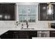 Modern kitchen features dark cabinetry, stainless steel appliances, and a window above the sink at 1504 Galloway Ln, Charleston, SC 29412