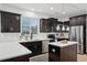 Modern kitchen with dark cabinets, marble countertops, stainless steel appliances, and ample natural light at 1504 Galloway Ln, Charleston, SC 29412