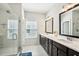Bathroom boasts a double vanity with dark cabinets, bright countertops, and a glass-enclosed shower at 1537 Cultivation Ln, Mount Pleasant, SC 29466
