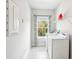 Well-lit laundry room with washer, dryer, utility sink, wire shelf, and window at 1537 Cultivation Ln, Mount Pleasant, SC 29466