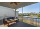 Screened in porch with cozy couch and coffee table, overlooking a scenic community pond and fountain at 1537 Cultivation Ln, Mount Pleasant, SC 29466