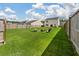 Large fenced backyard featuring green lawn, a fire pit, and play equipment at 163 Cypress Plantation Rd, Moncks Corner, SC 29461