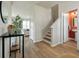 Hallway view with hard wood floors, staircase, and an open door to a powder room at 163 Cypress Plantation Rd, Moncks Corner, SC 29461