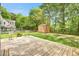 View of a backyard with a wooden deck, storage shed, fenced perimeter, fire pit and mature trees at 1708 Eallystockert Rd, Charleston, SC 29414
