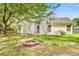 Backyard featuring mature trees, fire pit, fenced perimeter, and the home's back exterior with a deck at 1708 Eallystockert Rd, Charleston, SC 29414