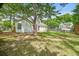 View of a backyard featuring mature trees, a fire pit, and home exterior with a deck and fencing at 1708 Eallystockert Rd, Charleston, SC 29414