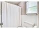 A bathroom featuring a white shower curtain, toilet, and window for natural light at 1708 Eallystockert Rd, Charleston, SC 29414