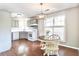 An eat-in kitchen featuring warm wood floors, grey cabinets, white appliances and a large window at 1708 Eallystockert Rd, Charleston, SC 29414
