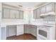 A bright eat-in kitchen with grey cabinets, a corner window and white countertops at 1708 Eallystockert Rd, Charleston, SC 29414