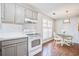 A light eat-in kitchen with warm wood floors, grey cabinets, and white appliances at 1708 Eallystockert Rd, Charleston, SC 29414