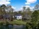 Backyard with lush lawn leading to waterfront view featuring a screened porch and fire pit area at 1749 James Basford Pl, Mount Pleasant, SC 29466