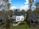 Aerial shot of the home's rear exterior with a screened-in porch, lush backyard, and cozy fire pit area at 1749 James Basford Pl, Mount Pleasant, SC 29466