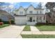 Charming two-story home featuring a welcoming front porch, attached garage, and manicured front lawn at 1749 James Basford Pl, Mount Pleasant, SC 29466