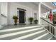 Inviting front porch with classic columns, potted plants, and an American flag, exuding Southern charm at 1749 James Basford Pl, Mount Pleasant, SC 29466