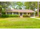 Charming single-story home with a well-maintained lawn, lush landscaping, and a covered carport at 1785 N Mayflower Dr, Charleston, SC 29412