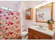 Charming bathroom with a floral shower curtain, vanity with marble top, and bright lighting at 1906 Cedar Petal Ln, Charleston, SC 29414