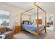 Bright bedroom featuring a four-poster bed, a wooden nightstand and colorful armchair at 1906 Cedar Petal Ln, Charleston, SC 29414