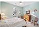 Bright bedroom with light blue walls, a large window, and hardwood furniture accents at 1906 Cedar Petal Ln, Charleston, SC 29414