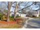 Inviting home exterior featuring a manicured lawn, mature trees, and a two-car garage at 1906 Cedar Petal Ln, Charleston, SC 29414
