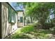 A green backyard featuring a home with green shutters and lush trees at 2 Leone Ln, Hanahan, SC 29410