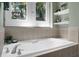 A soaking tub with tile surround and views to the outside at 2 Leone Ln, Hanahan, SC 29410