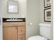 Cozy bathroom featuring a wooden vanity with granite top, toilet, and framed artwork at 2 Leone Ln, Hanahan, SC 29410