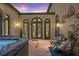 Charming courtyard with a hot tub, inviting seating, and access through arched doors, creating a private outdoor oasis at 2 Leone Ln, Hanahan, SC 29410