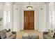 Grand entryway featuring impressive wooden double doors, complemented by bright light and architectural pillars, creating a striking focal point at 2 Leone Ln, Hanahan, SC 29410