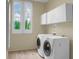 Convenient laundry room with white washer and dryer, cabinetry, and natural light at 2 Leone Ln, Hanahan, SC 29410