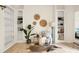 Charming living room with built-in shelves, decorative accents, and a cozy seating area with a unique rug on light-colored wood floors at 2 Leone Ln, Hanahan, SC 29410