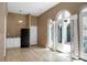 Bright living room with wood floors, a black refrigerator, and arched doorways leading outside at 2 Leone Ln, Hanahan, SC 29410
