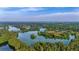 Scenic aerial view of a serene lake surrounded by lush green forests and vegetation under a blue sky at 202 Morning Song St, Summerville, SC 29485