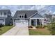 Inviting home showcases gray siding, a two-car garage, and a neatly manicured front lawn at 202 Morning Song St, Summerville, SC 29485