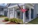Cozy front porch includes white pillars, rocking chairs, and an American flag accent at 202 Morning Song St, Summerville, SC 29485