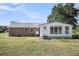 Rear exterior view showcasing brick facade, sunroom addition, and expansive yard at 217 Mini Farm Rd, Bonneau, SC 29431