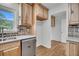 Well-lit kitchen with wooden cabinetry, brick backsplash and stainless steel dishwasher at 217 Mini Farm Rd, Bonneau, SC 29431