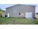 Exterior view of the outbuilding with a metal roof, small door, two windows, and green grass at 217 Mini Farm Rd, Bonneau, SC 29431