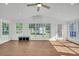 Bright sunroom featuring neutral walls, tile floors, many windows with backyard views, and modern ceiling fan at 217 Mini Farm Rd, Bonneau, SC 29431