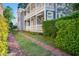 Side view of the home featuring a brick pathway, lush landscaping and covered entryway at 22 Ashton St, Charleston, SC 29403