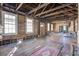Spacious unfinished living room with exposed beams, natural light, and original wood flooring; renovation opportunity at 22 Ashton St, Charleston, SC 29403