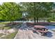 Scenic view of a community picnic area, featuring a charming picnic table next to a paved walkway, adjacent to tennis courts at 2221 Chatelain Way, Mount Pleasant, SC 29464
