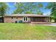Backyard featuring a brick house, screened-in porch, grassy lawn and mature tree at 223 Dandridge Rd, Walterboro, SC 29488