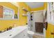 Bright bathroom with white vanity, shower, and floating shelves against yellow walls at 223 Dandridge Rd, Walterboro, SC 29488