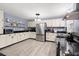 Well-lit kitchen with stainless steel appliances, custom cabinetry and black countertops at 223 Dandridge Rd, Walterboro, SC 29488