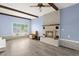 Cozy living room featuring a brick fireplace, wood beams, and large windows at 223 Dandridge Rd, Walterboro, SC 29488