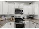 Close up of a kitchen featuring white cabinets, granite counters and stainless steel appliances at 223 Goshen Rd, Moncks Corner, SC 29461