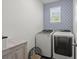 Laundry room with patterned wallpaper, front loading washer and dryer, and a storage cabinet at 223 Goshen Rd, Moncks Corner, SC 29461