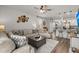 Living room featuring neutral furniture, a ceiling fan, and an open view of the kitchen at 223 Goshen Rd, Moncks Corner, SC 29461