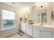 Bright bathroom features a double vanity with white cabinets, and a window view of the neighborhood at 227 Oak View Way, Summerville, SC 29483